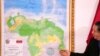 El presidente de la Comisión Especial para la Defensa del Territorio de la Guyana Esequiba, Hermann Escarra, de pie junto al nuevo mapa de Venezuela que incluye el Esequibo, durante una ceremonia de develación en Caracas, el 8 de diciembre de 2023. 