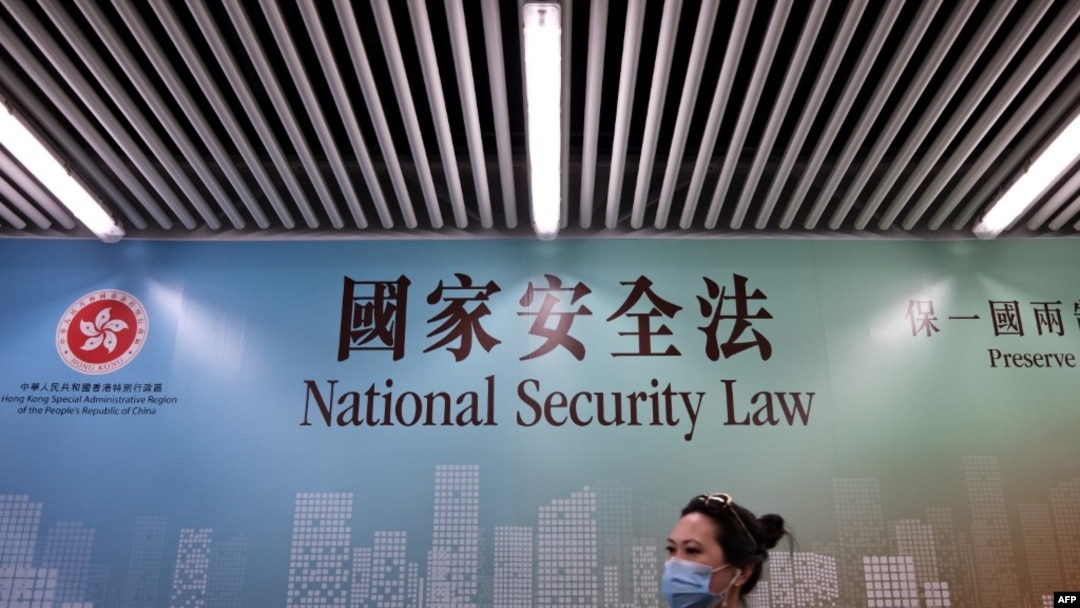行人走過香港街頭港版國安法的宣傳牌。 （2020年7月28日）