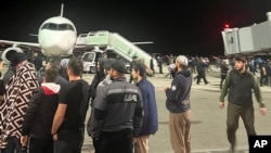 People in the crowd walk shouting antisemitic slogans at an airfield of the airport in Makhachkala, Russia, Monday, Oct. 30, 2023. (AP Photo)