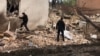 Policajci u blizini ruševina lokalnog muzeja teško oštećenog ruskim raketnim udarom u gradu Kupjansk, oblast Harkov, 25. april 2023. (Pres služba Nacionalne policije Ukrajine u oblasti Harkov/preko Rojtersa)