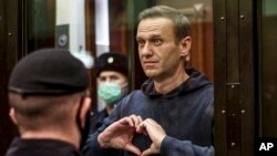 ARCHIVO - Fotografía tomada de una filmación proporcionada por el Tribunal Municipal de Moscú, el líder de la oposición rusa Alexei Navalny muestra un símbolo escuchando de pie una audiencia sobre su caso, el martes 2 de febrero de 2021. Nalvany falleció en prisión a los 47 años.