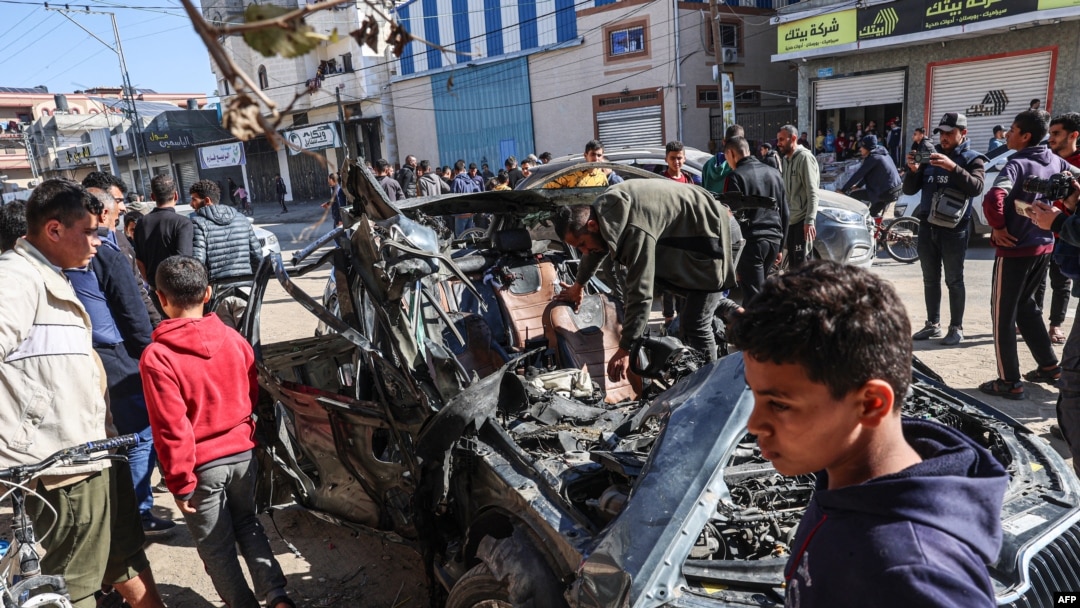 FILE - People check a car in which two journalists, Mustafa Thuria, a video stringer for news service Agence France-Presse, and Hamza Wael Dahdouh, a journalist with Al Jazeera television network, were killed in the Gaza Strip on Jan. 7, 2024. 