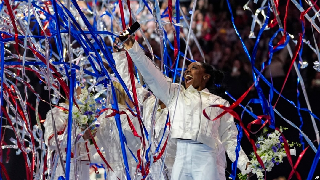 FILE - Simone Biles and the U.S. women celebrate as the 2024 team is named at the United States Gymnastics Olympic Trials in Minneapolis, June 30, 2024.