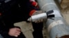 FILE - A member of the Ukrainian military holds a defused cluster bomb among a display of pieces of Russian army rockets that a Ukrainian munitions expert said did not explode on impact, in Kharkiv region, Ukraine, Oct. 21, 2022. 