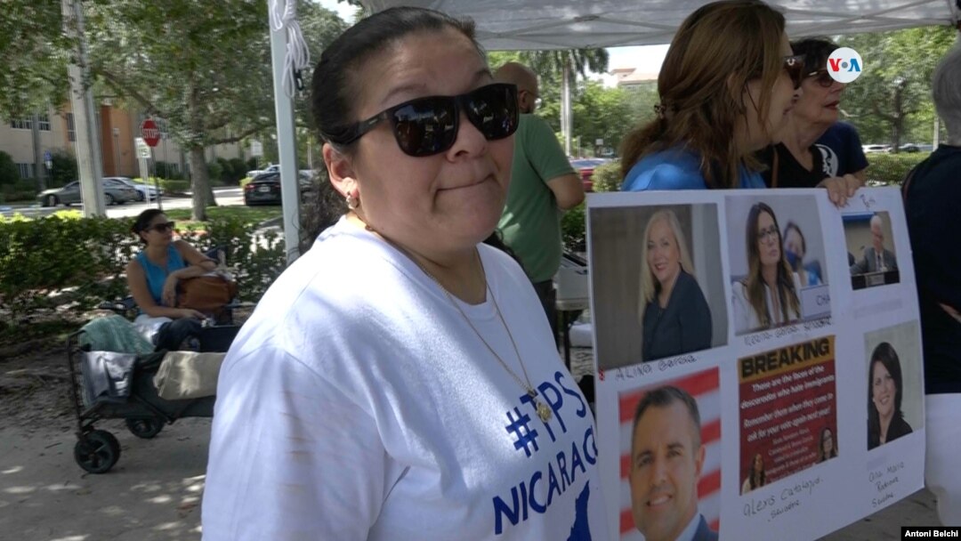 Bertha Sanles, que lleva indocumentada en Florida desde hace dos décadas, posa junto a un cartel con las fotografías de algunos legisladores estatales que aprobaron la ley SB 1718 contra la migración irregular. 