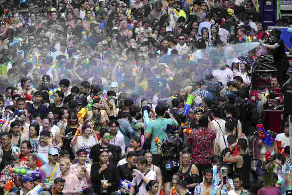 Thai officer spray water from fire hose during the Songkran water festival to celebrate the Thai New Year in Bangkok, Thailand, April 13, 2024.