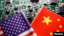 FILE - Flags of China and U.S. are displayed on a printed circuit board with semiconductor chips, in this illustration picture taken Feb. 17, 2023. 