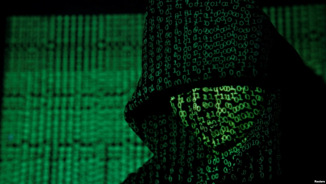 FILE - Binary code is projected onto a hooded person in this illustration photo taken on May 13, 2017. (TPX Images via Reuters)