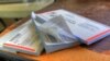 A stack of checkbooks. Many Native Americans lack access to banks and because of poor broadband access can't bank online.