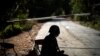 FILE - A Thai soldier sits in front of the blockage of a road near the Thailand-Myanmar border, in Mae Sot district, Tak province, Thailand, Dec. 19, 2021. 