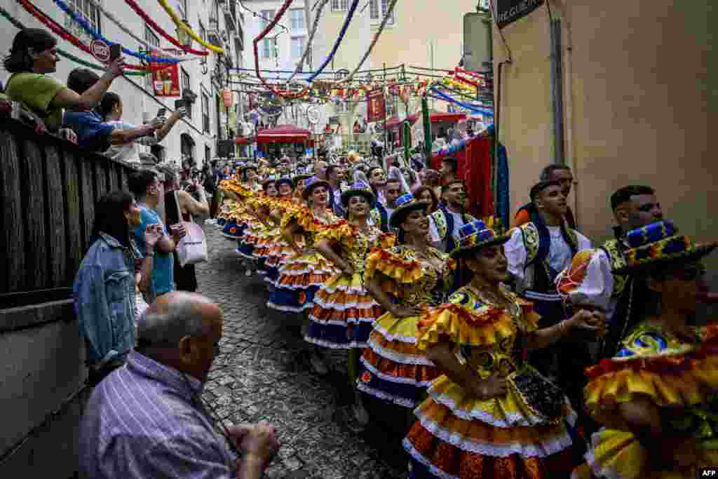 Revelers from the Alfama neighborhood parade in the streets before attending the Santo Antonio de Lisboa's Parade on Avenida da Liberdade, in Lisbon, Portugal, June 12, 2023.