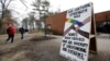 FILE - Students walk by a pop-up exhibit following a series of racist incidents on campus, at the University of New Hampshire in Durham, New Hampshire, April 19, 2018. 