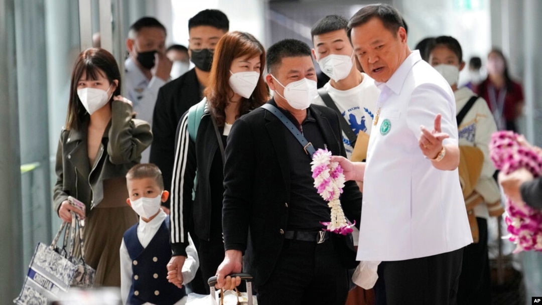泰國素萬那普國際機場，泰國公共衛生部長阿努廷·查恩維拉庫（Anutin Charnvirakul）向抵達機場的中國遊客贈送花環。（2023年1月9日）