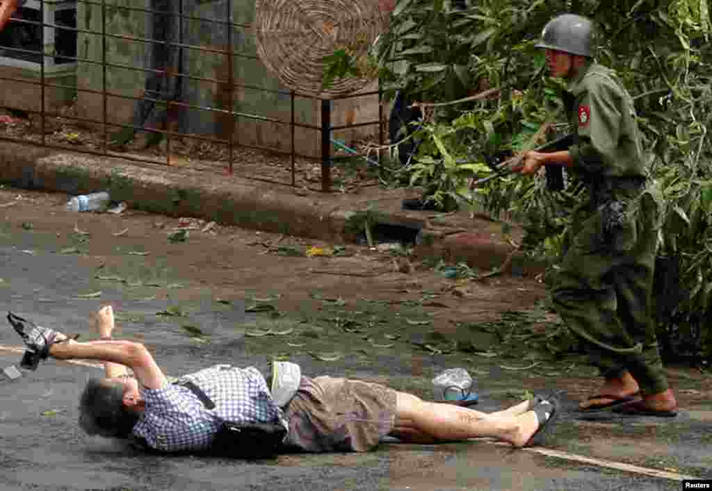 In this unseen footage released, April 26, 2027, by the family of slain Japanese journalist, Kenji Nagai of APF News, tries to take photographs as he lies injured after police and military officials fired upon and then charged at protesters in Yangon's city center, Myanmar, Sept. 27, 2007.