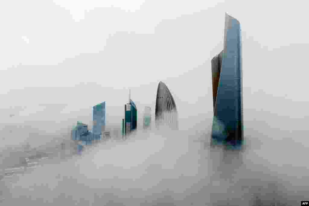This aerial picture shows highrise-buildings during a foggy morning in Kuwait City.