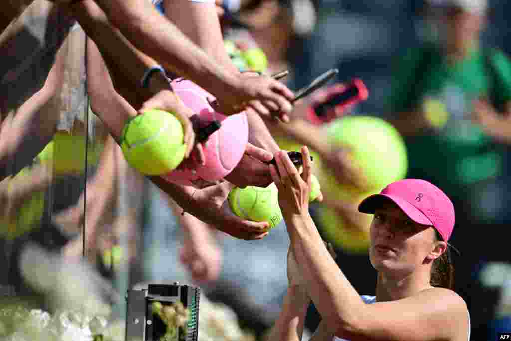 Poland's Iga Swiatek signs autographs after winning against Germany's Angelique Kerber during the Women's WTA Rome Open tennis tournament at Foro Italico in Rome, Italy.