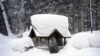 Seorang calon penumpang duduk di halte bus yang tertutup salju di Olympic Valley, California, 24 Februari 2023. California dan sebagian wilayah Barat diguyur hujan dan salju lebat dari badai musim dingin. (Foto: John Locher/AP Photo)
