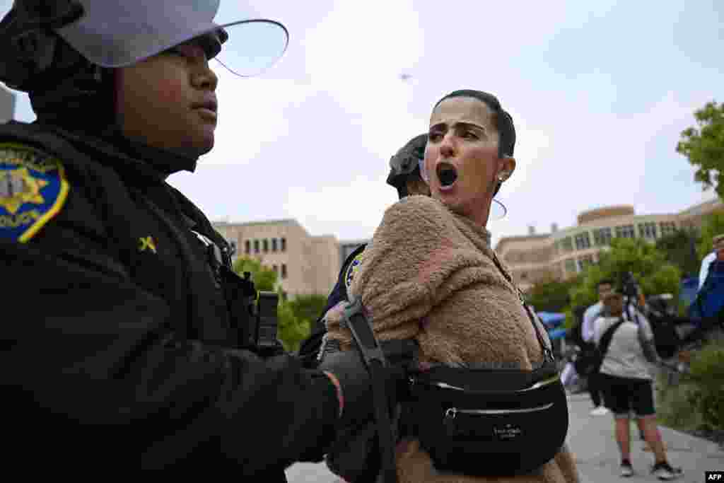 A pro-Palestinian demonstrator is arrested by police as an encampment is cleared after occupying and barricading the Physical Sciences Lecture Hall at the University of California, Irvine, in Irvine, California, May 15, 2025.