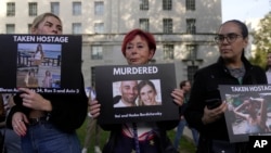 民眾手舉被巴勒斯坦武裝份子殺害和劫為人質的以色列婦女與兒童的照片在倫敦的英國首相官邸唐寧街10號外舉行支持以色列的集會。（2023年10月9日）