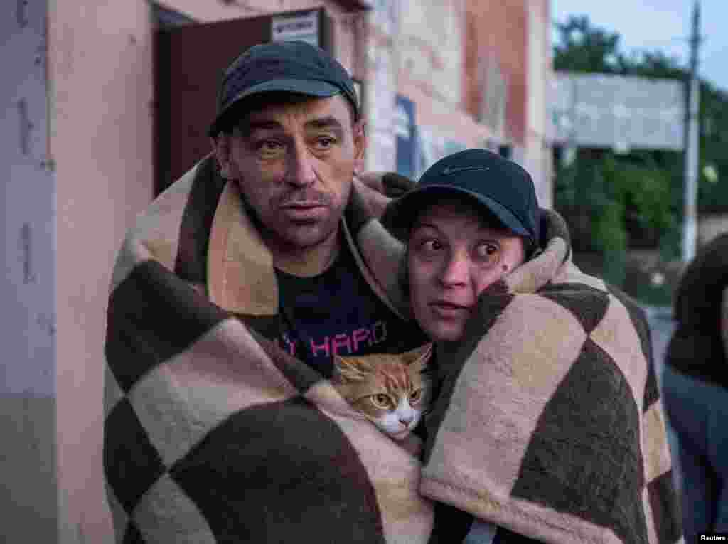 Local residents react after their evacuation from a flooded area after the Nova Kakhovka Dam breached in Kherson, Ukraine, June 6, 2023.