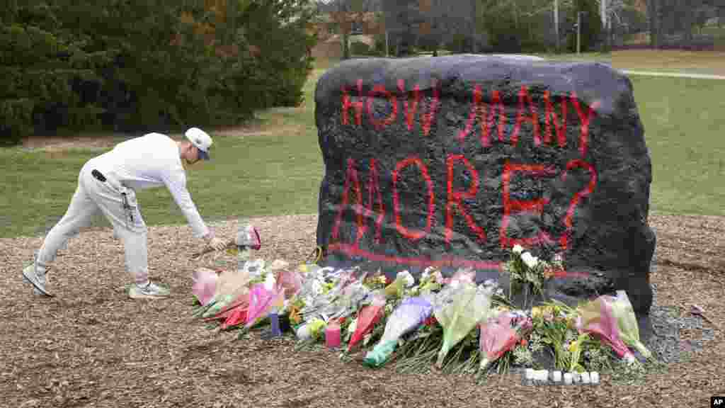 A student leaves flowers at The Rock on the grounds of Michigan State University, in East Lansing, Michigan, Feb. 14, 2023. A gunman killed three students and critically wounded five others on the campus. Police said that the shooter eventually killed himself. 