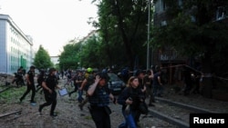 La gente corre a refugiarse, tras el anuncio de un ataque con misiles rusos hacia Kharkiv, en el lugar de un edificio de oficinas que fue alcanzado por un ataque aéreo ruso, el 25 de mayo de 2024.