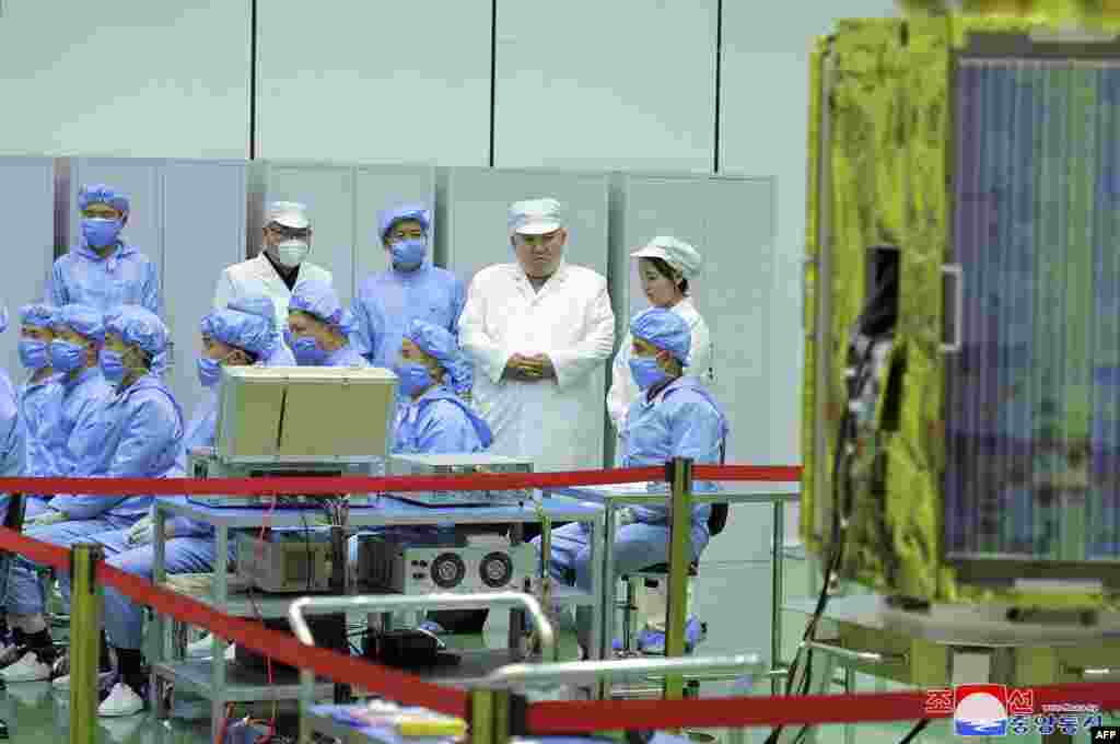 North Korean leader Kim Jong Un, 2nd right at top, and his daughter, presumed to be named Ju Ae, right at top, inspect a military reconnaissance satellite at an undisclosed location in North Korea, in this picture taken on May 16, 2023, and released May 17. Kim Jong Un has inspected North Korea's first military spy satellite and gave the go-ahead for its "future action plan," state media said on May 17. (Photo by KCNA via KNS / AFP)