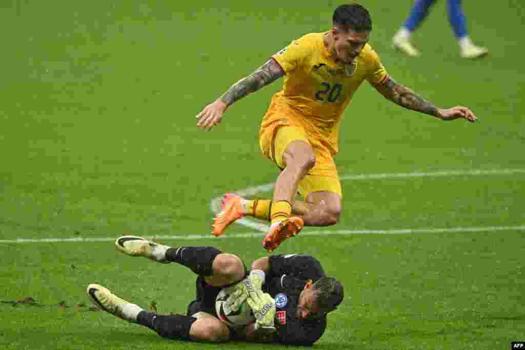 Slovakia's goalkeeper #01 Martin Dubravka saves at the feet of Romania's forward #20 Dennis Man during the UEFA Euro 2024 Group E football match between Slovakia and Romania at the Frankfurt Arena in Frankfurt, Germany.