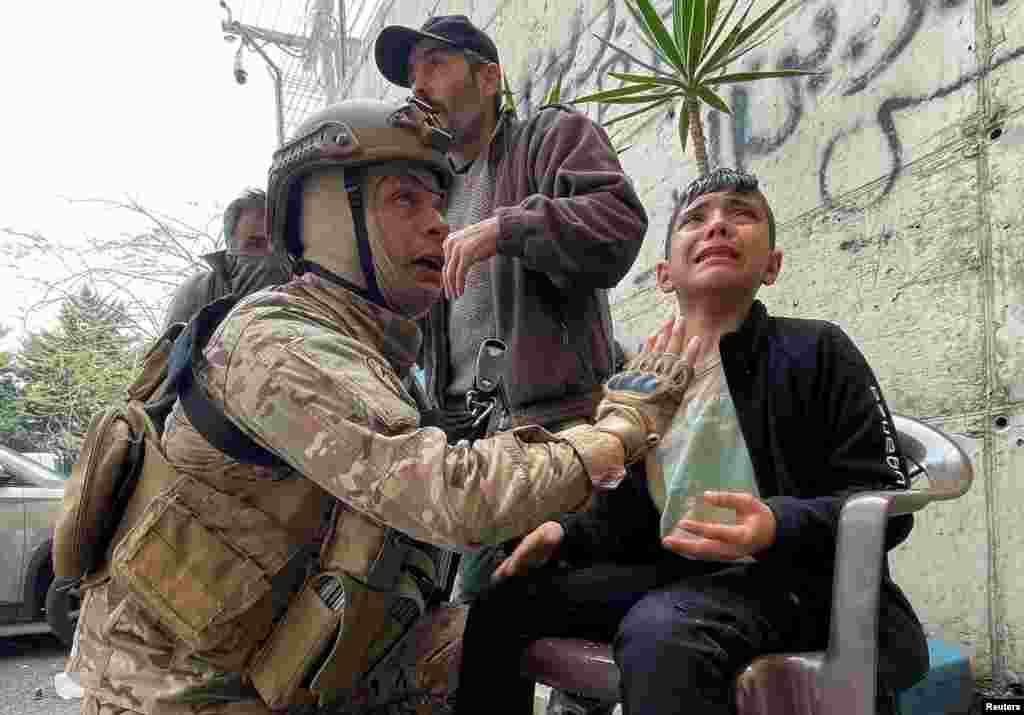 A Lebanese army soldier assists a boy affected by tear gas, during a protest over the deteriorating economic situation in Beirut.