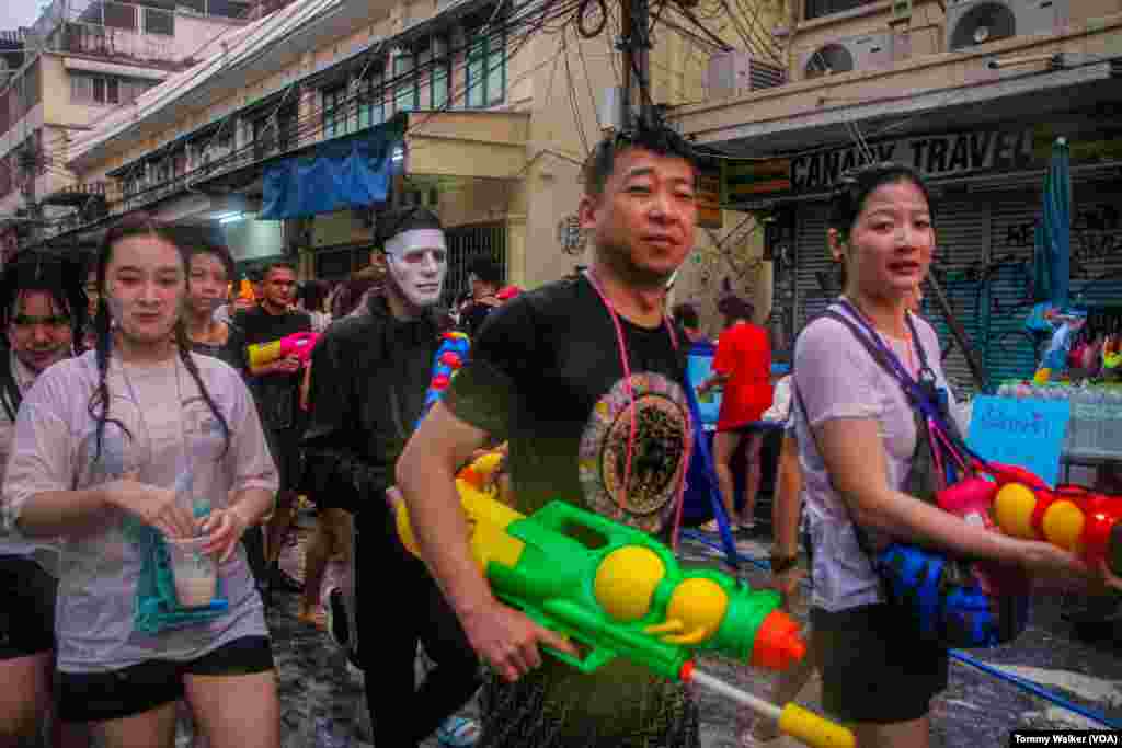 Thais use toy water guns to douse others with water as a cleansing ritual for Songkran, Bangkok, April 13, 2024.