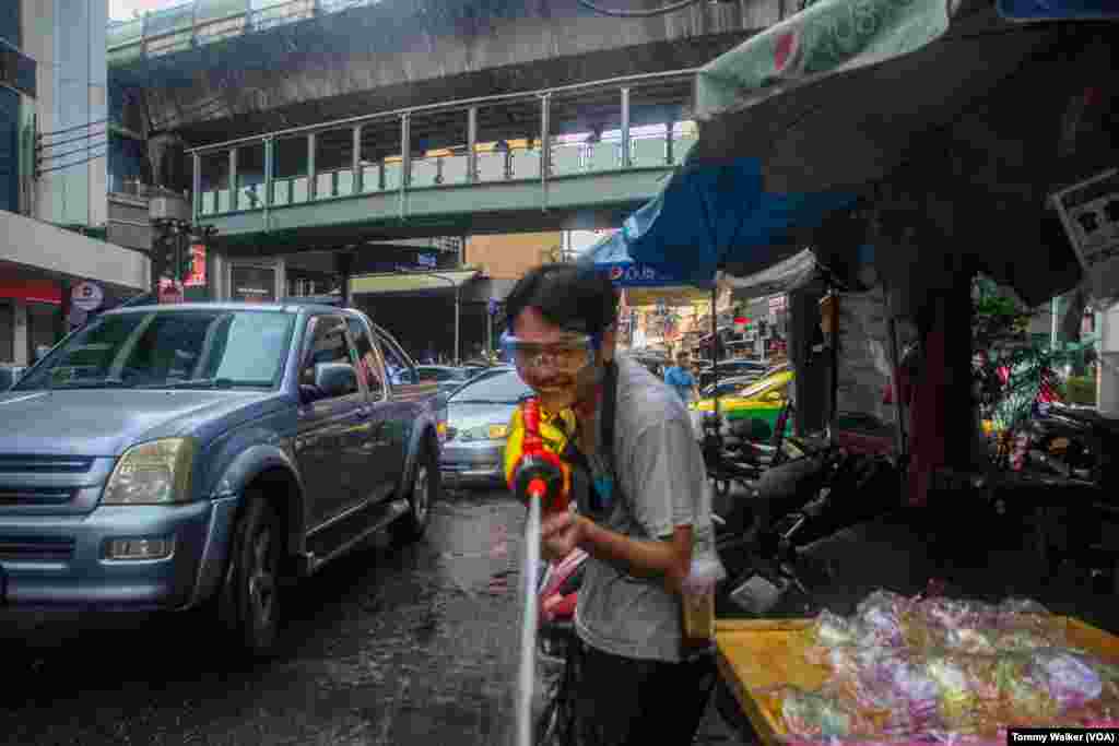 Thais use toy water guns to douse others with water as a cleansing ritual for Songkran, Bangkok, April 13, 2024.