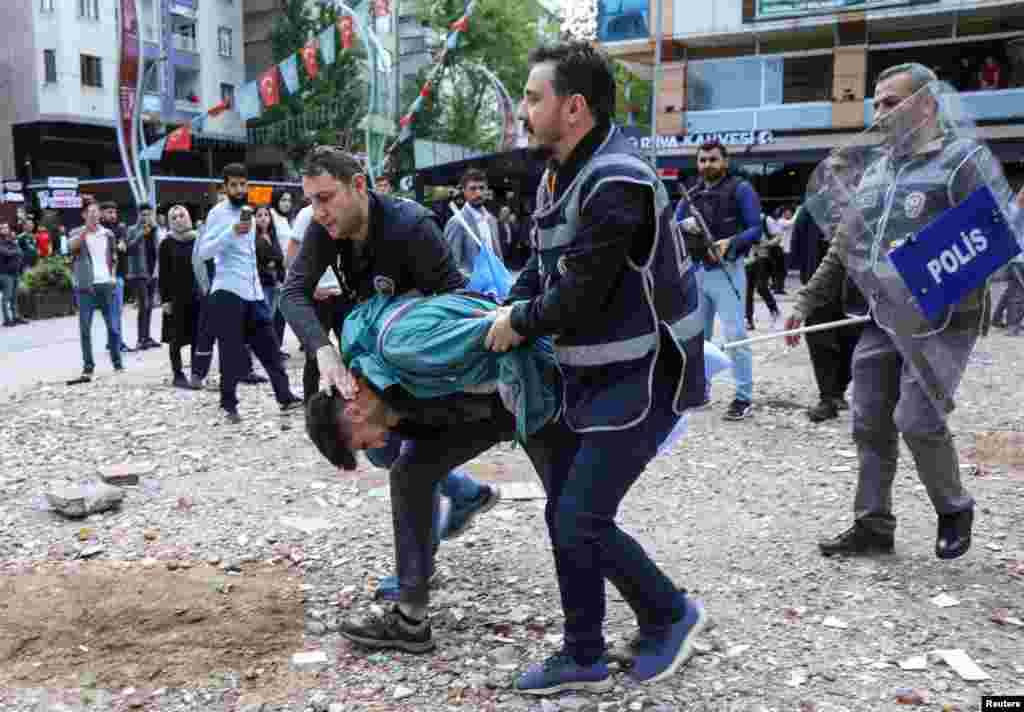 A man is detained by police officers as protesters demonstrate against the detention of 110 people over alleged militant ties, as per the security sources, in Diyarbakir, Turkey, April 25, 2023.