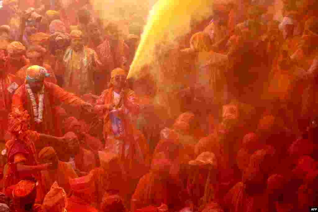 Devotees smear with colors as they celebrate Hindu spring festival of Holi at Shreeji temple in Barsana, Mathura district, India, Feb. 27, 2023.