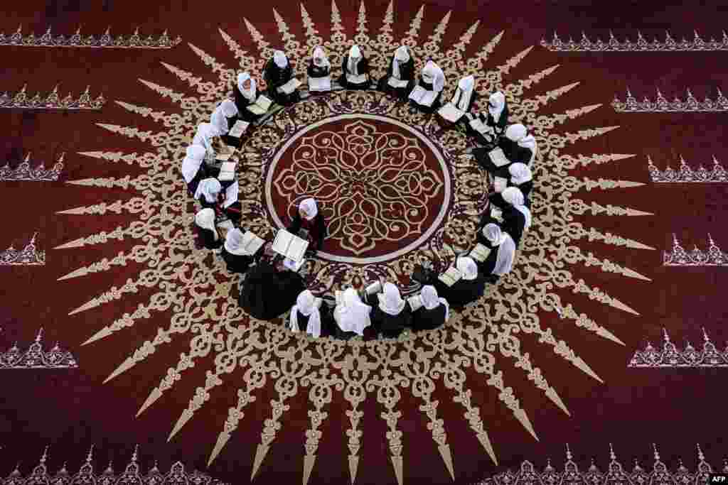 Palestinian Muslim girls sit together in a circle at a class for the recitation of the Quran, Islam's holy book, during a summer camp at a mosque in Gaza city.