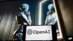 FILE - The OpenAI logo is seen displayed on a cellphone with an image on a computer monitor generated by ChatGPT's Dall-E text-to-image model in Boston, Massachusetts, Dec. 8, 2023.