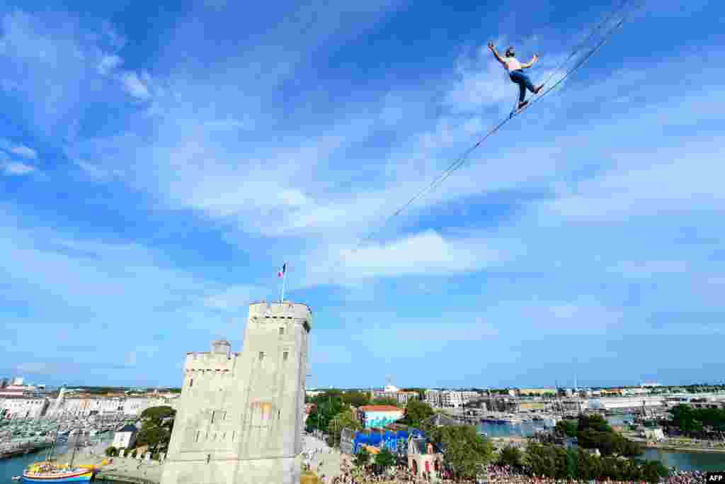 Tightrope walker Nathan Paulin performs a 50-meter-high and 277-meter-long rope displayed between the Lantern Tower and the Saint-Nicolas Tower above the old port in La Rochelle, France, June 7, 2023.