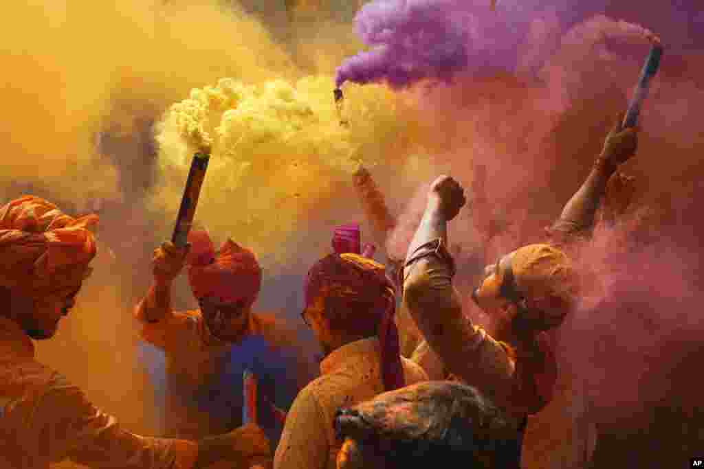 People sing, dance and throw colors at each other to celebrate Holi festival in Hyderabad, India.