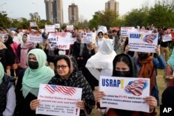 Pengungsi Afghanistan memegang plakat saat unjuk rasa memprotes penundaan pemrosesan visa AS, di Islamabad, Pakistan, 26 Februari 2023.