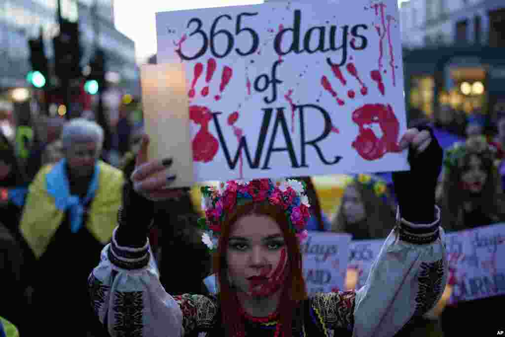A Ukrainian supporter holds a placard to mark the one-year anniversary of the full-scale Russian invasion of Ukraine, as people march to the Russian Embassy, in London.