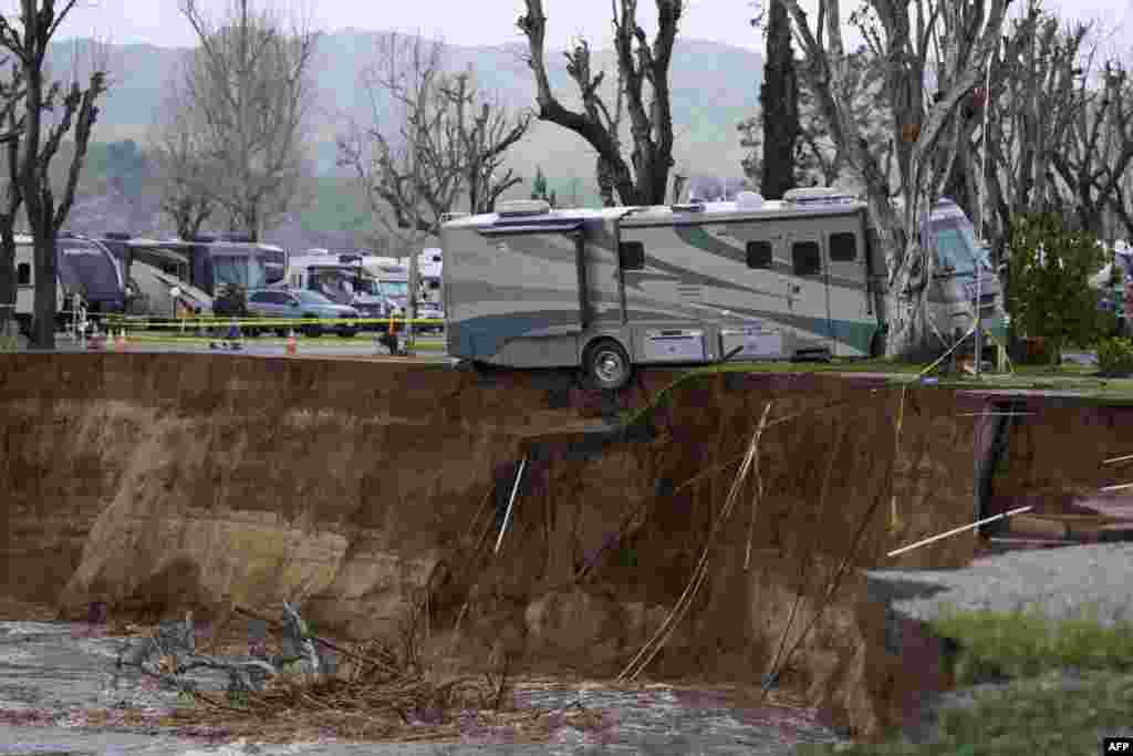 An RV begins to fall into the Santa Clara River as the ground is washed away by flooding due to heavy rain in Castaic, California, Feb. 25, 2023.