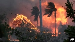 FILE - The hall of historic Waiola Church in Lahaina and nearby Lahaina Hongwanji Mission are engulfed in flames along Wainee Street on Aug. 8, 2023, in Lahaina, Hawaii.