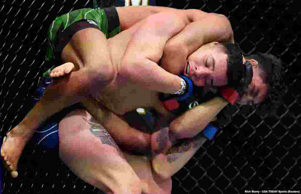 Raul Rosas Jr (red gloves) fights Christian Rodriguez (blue gloves) during UFC 287 at Miami-Dade Arena in Miami, Florida, April 8, 2023.