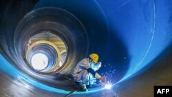 中國江蘇連雲港一家工廠的工人在焊接一個風井。（2023年5月31日）