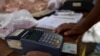 Un vendedor utiliza un dispositivo de punto de venta (POS) en un mercado de frutas y verduras al aire libre en Caracas, Venezuela, 10 de febrero de 2023.