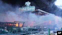 Los bomberos apagaron un incendio después de que dos bombas guiadas alcanzaran una tienda de suministros de construcción en Járkov, Ucrania, el 25 de mayo de 2024. La escritura dice "Centro Jardín".