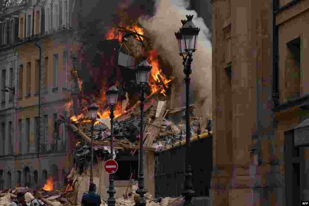 Smoke billows from the rubble of a building at Place Alphonse-Laveran in the 5th arrondissement of Paris. A major fire of unknown origin broke out in a building in central Paris, part of which collapsed, injuring at least one person.