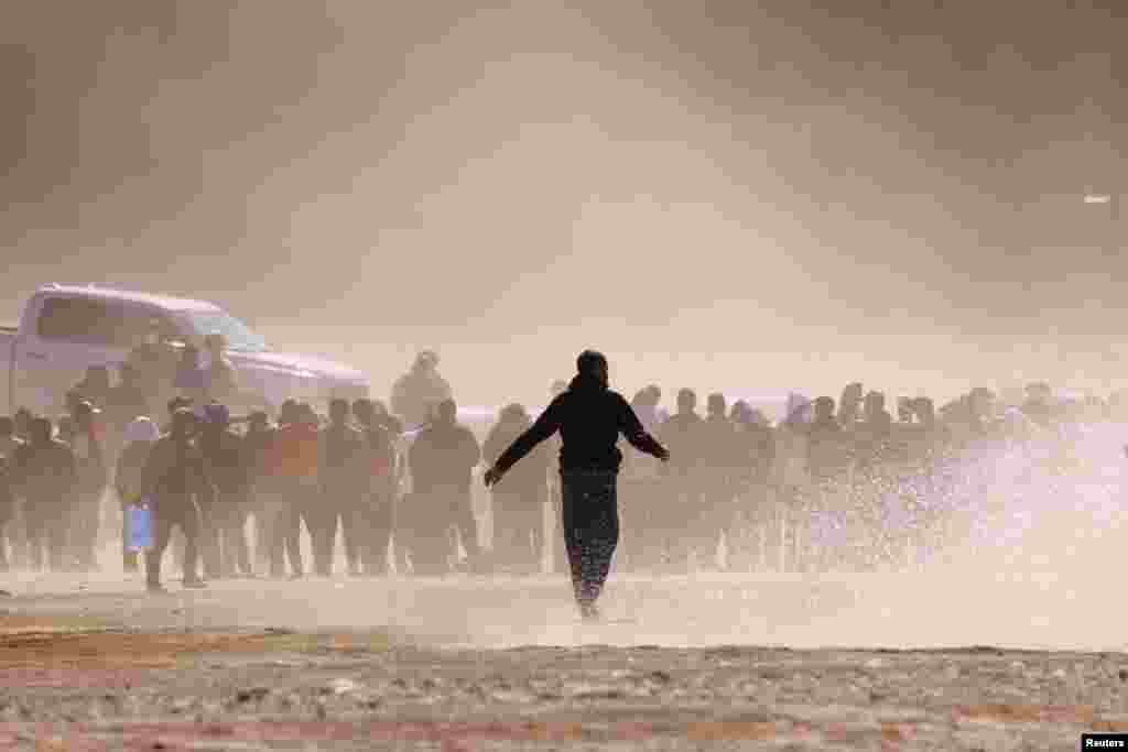 Migrants stand near the border wall after crossing the Rio Bravo river with the intention of turning themselves in to the U.S. Border Patrol agents, as seen from Ciudad Juarez, Mexico, April 25, 2023.