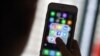 FILE - A woman looks at social networking apps Facebook, Instagram, Snapchat, Whatsapp, Twitter, Messenger and Linkedin on a smartphone in Kuala Lumpur, March 22, 2018.