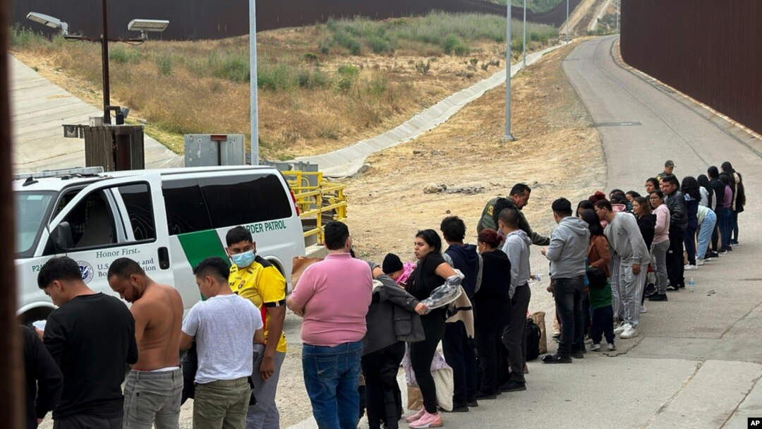 FILE - Migrants seeking asylum line up while waiting to be processed after crossing the border in San Diego, California, June 5, 2024. 