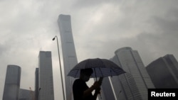 2023年7月12日，中國北京雨天，一名男子行走在中央商務區。（路透社照片）